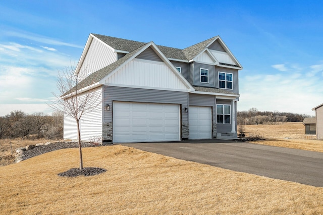 view of front of home featuring a garage, roof with shingles, board and batten siding, and aphalt driveway