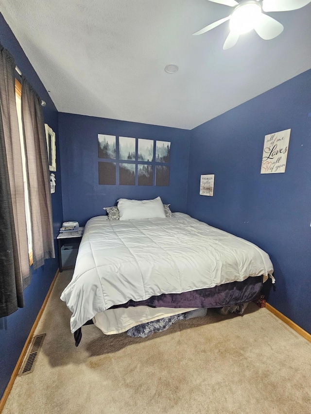 bedroom featuring ceiling fan, carpet flooring, visible vents, and baseboards