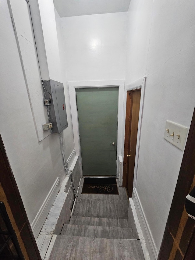 doorway to outside featuring electric panel and baseboards