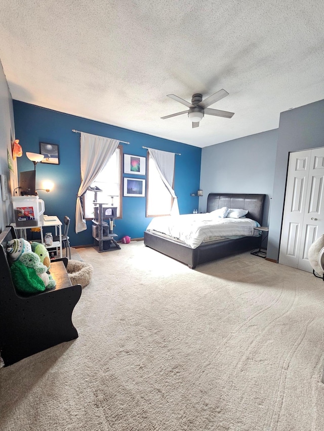 bedroom featuring carpet floors, a textured ceiling, and a ceiling fan