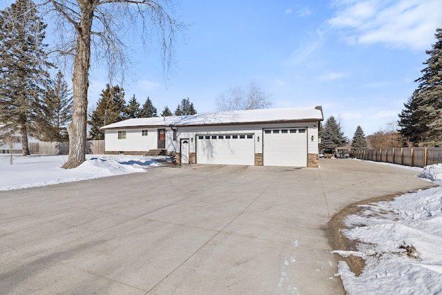 single story home featuring a garage, fence, and driveway