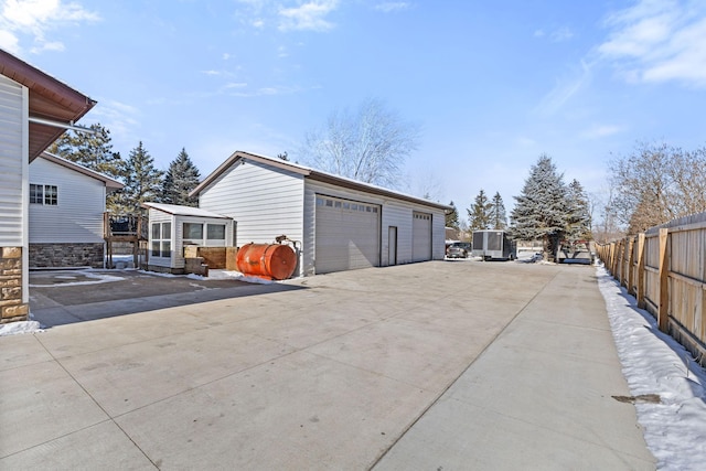 view of home's exterior with a garage, an outdoor structure, and fence