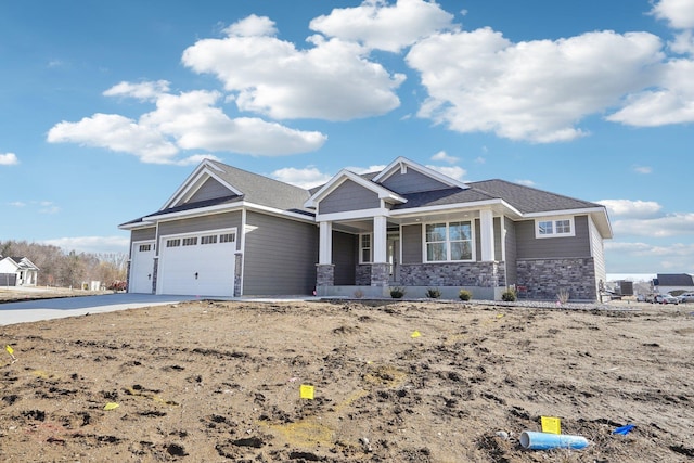 view of front of property featuring a porch, a garage, stone siding, and concrete driveway