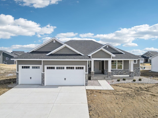 craftsman house with stone siding, driveway, a garage, and roof with shingles