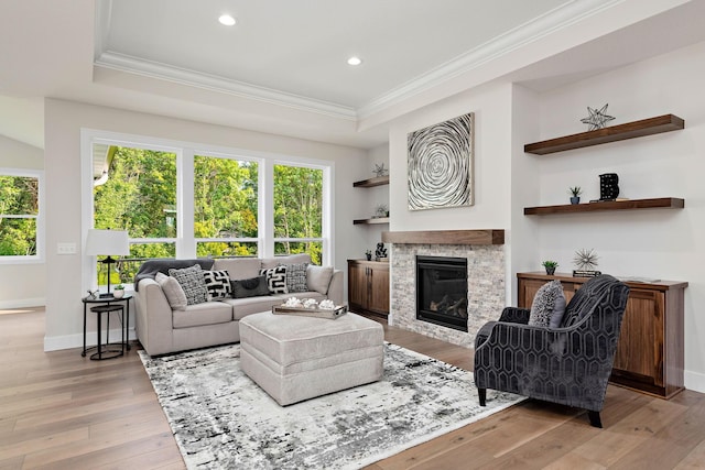 living area with ornamental molding, a wealth of natural light, and light wood-style flooring