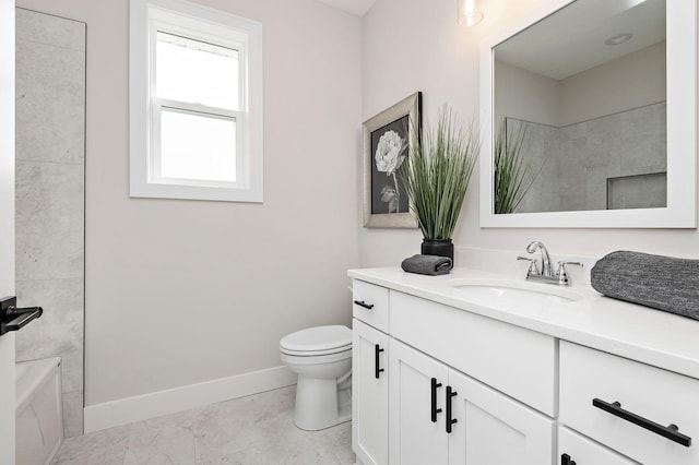 bathroom with vanity, toilet, and baseboards