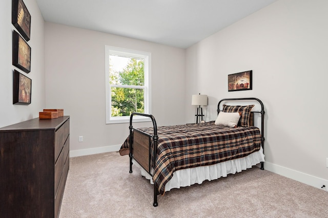 bedroom featuring light carpet and baseboards