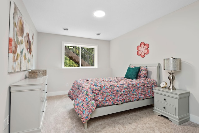 bedroom with light carpet and baseboards