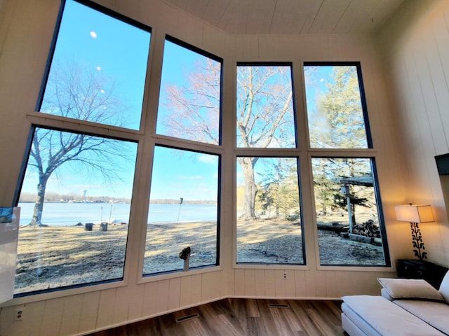 interior space with wood ceiling, a water view, and visible vents