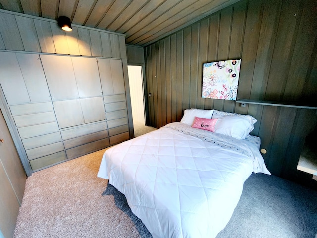 carpeted bedroom with wood walls and wooden ceiling