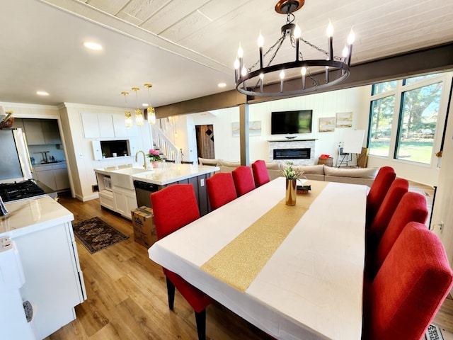 dining space with recessed lighting, stairs, wood finished floors, and a chandelier