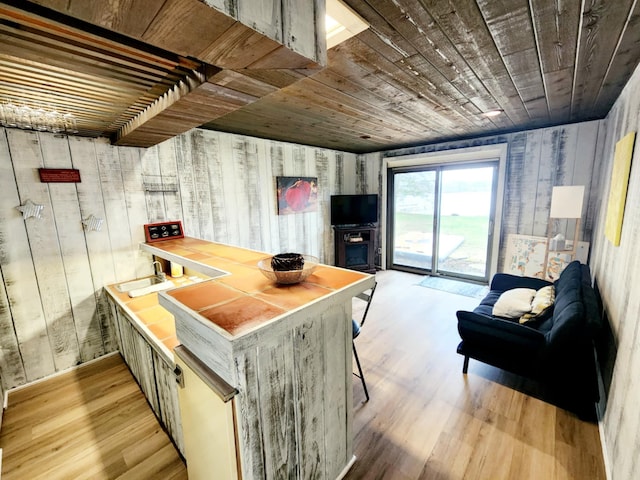 kitchen with wood walls, wooden ceiling, and light wood-style floors