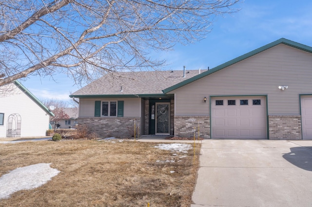 view of front of home featuring an attached garage, roof with shingles, concrete driveway, and brick siding