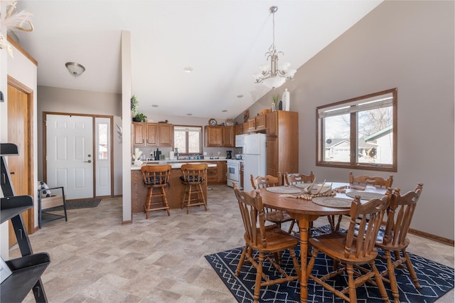 dining room featuring lofted ceiling, baseboards, and an inviting chandelier