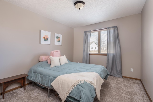 bedroom featuring carpet floors, baseboards, and a textured ceiling