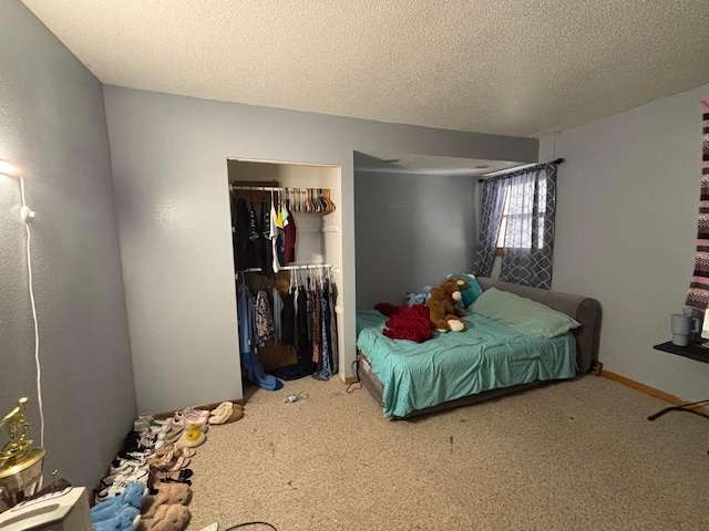 carpeted bedroom with a textured ceiling, baseboards, and a closet