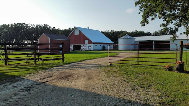 view of community with a yard, a pole building, an outdoor structure, and a garage