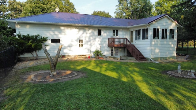 rear view of house featuring stairs, metal roof, a yard, and a wooden deck