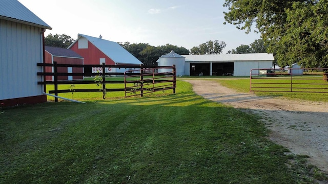 view of yard with an outbuilding, driveway, and an exterior structure