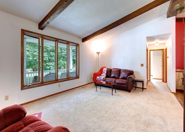 carpeted living area featuring lofted ceiling with beams, a textured ceiling, and baseboards