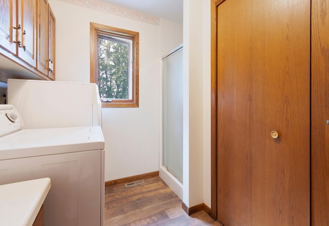 laundry room with light wood-type flooring, washer / clothes dryer, cabinet space, and baseboards