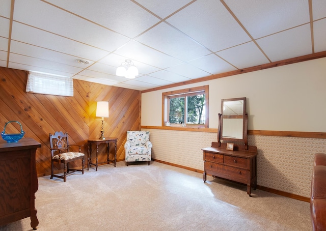 sitting room with a wainscoted wall, carpet floors, and a paneled ceiling