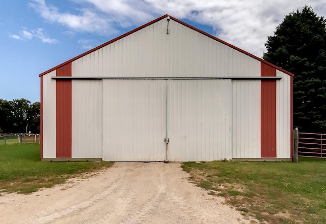 view of pole building with a yard and fence