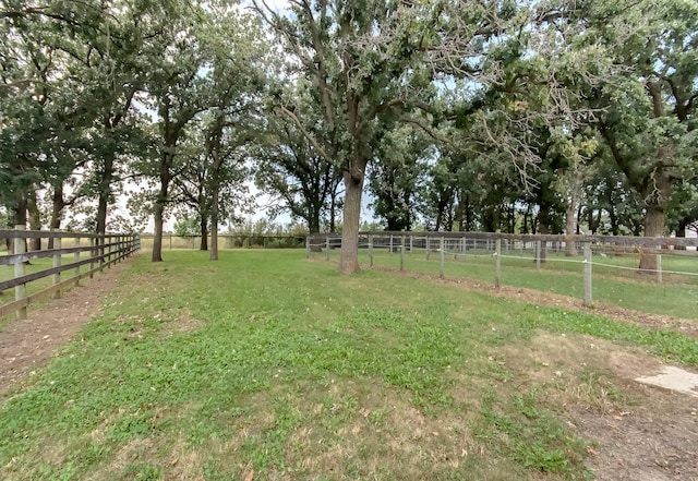 view of yard with fence and a rural view