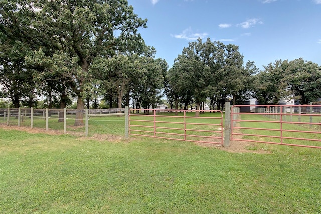 view of yard with a rural view, fence, and a gate