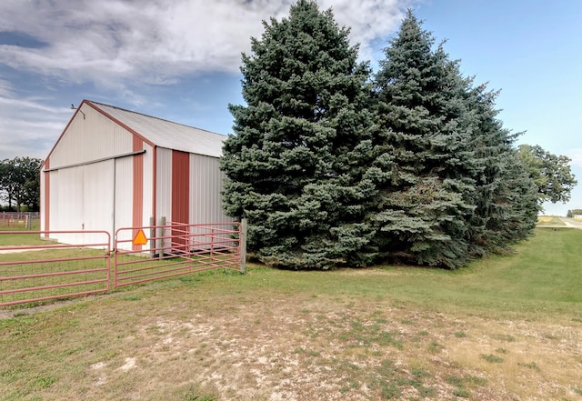 view of yard with an outbuilding, a detached garage, and fence