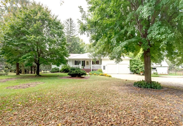 single story home featuring an attached garage, driveway, a front lawn, and a porch