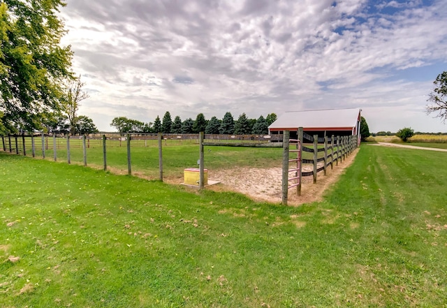 view of yard with an exterior structure, a rural view, and an outdoor structure