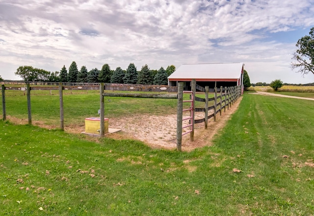 view of yard featuring an exterior structure, a pole building, a rural view, and an outdoor structure