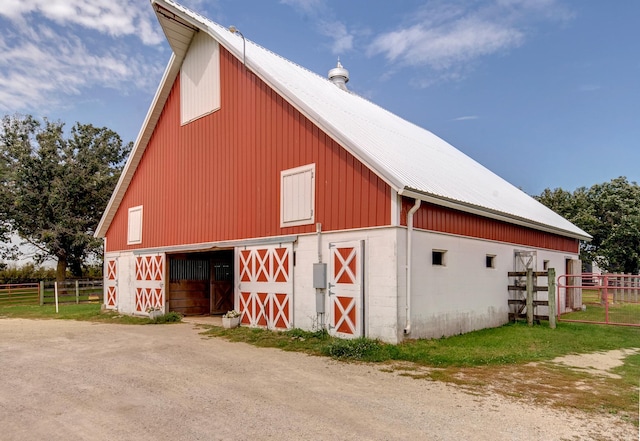 view of barn featuring fence