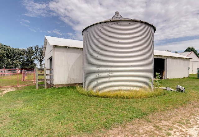 view of home's exterior with a pole building, fence, an outbuilding, and a yard