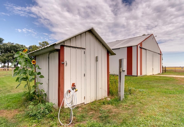 view of pole building with a lawn and fence