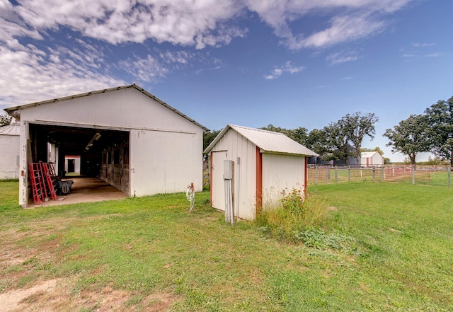 view of pole building featuring fence and a yard