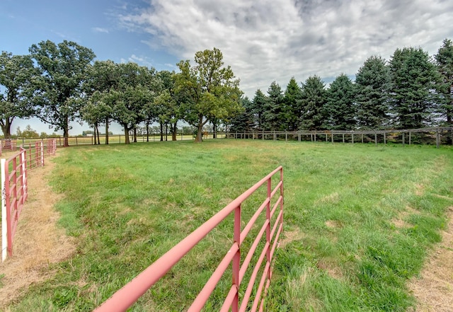 view of yard with fence and a rural view