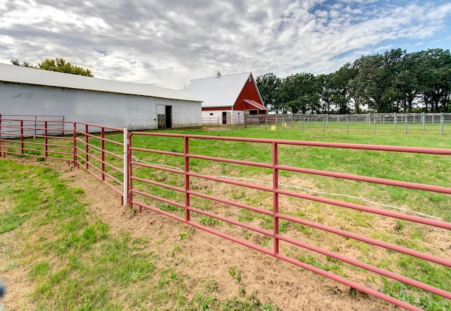 view of gate with a rural view, an outdoor structure, and an exterior structure