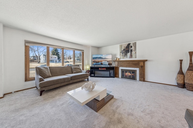 living room with a fireplace with flush hearth, carpet flooring, a textured ceiling, and baseboards