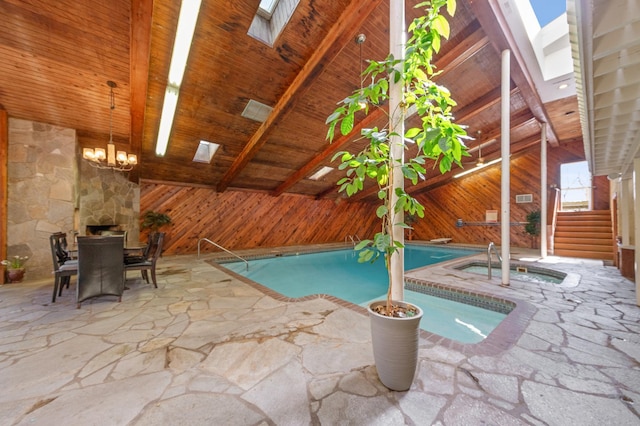 pool featuring a patio, outdoor dining space, and an indoor hot tub