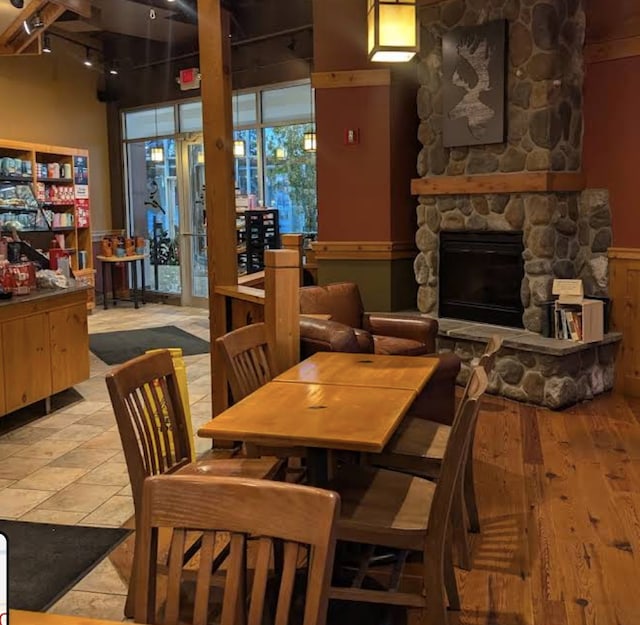 dining space with hardwood / wood-style flooring and a fireplace