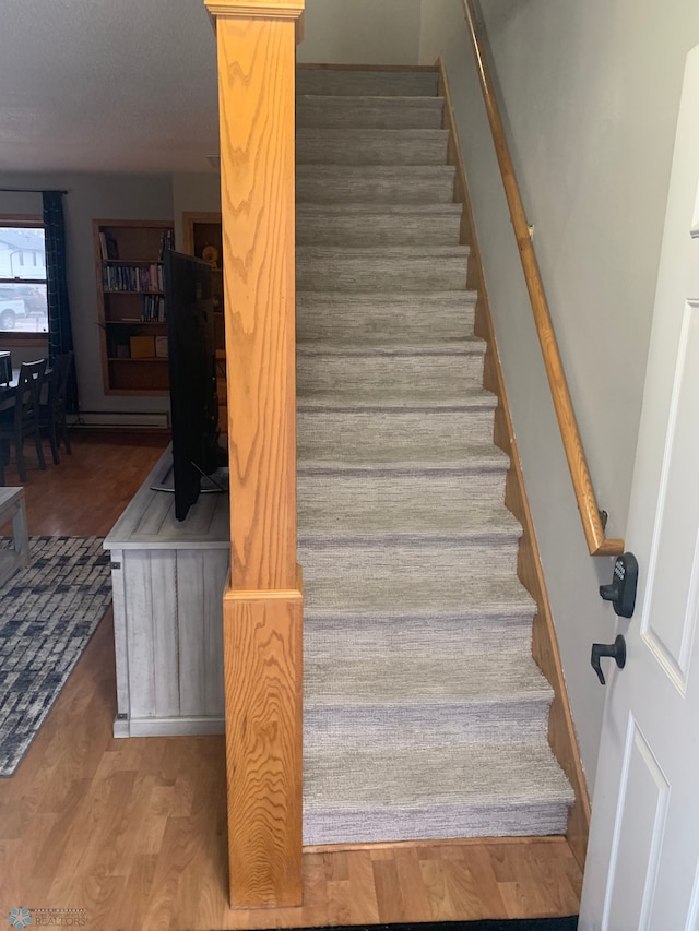 stairs featuring wood finished floors