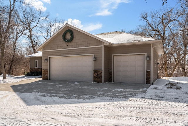 view of front of property with a garage and stone siding