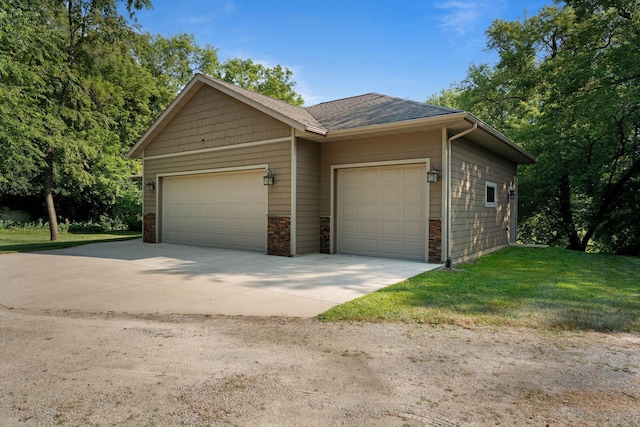 view of front of home featuring roof with shingles, an attached garage, and a front lawn