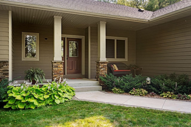 view of exterior entry featuring a porch, stone siding, and roof with shingles