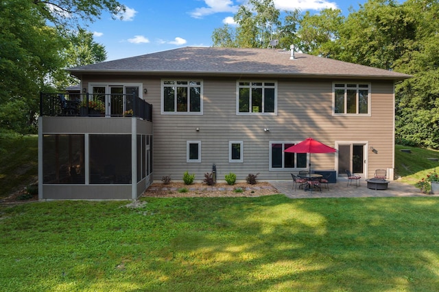 back of house with a fire pit, a balcony, a sunroom, a yard, and a patio area