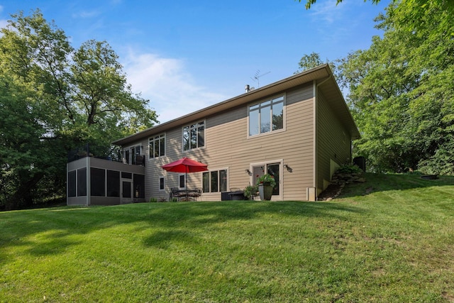 back of property featuring a lawn and a sunroom