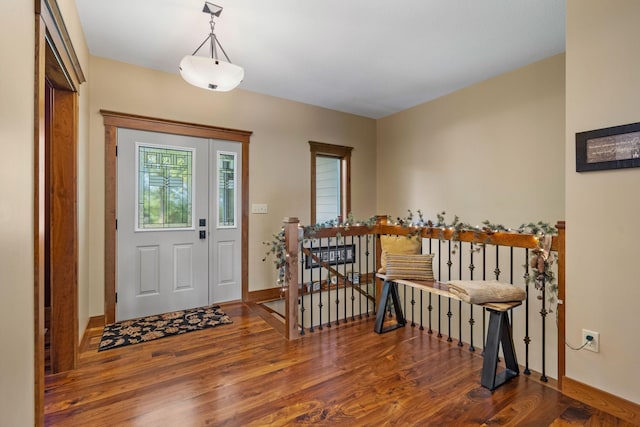 foyer with dark wood-style floors and baseboards