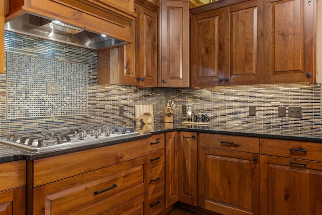 kitchen with brown cabinets, wall chimney range hood, and decorative backsplash